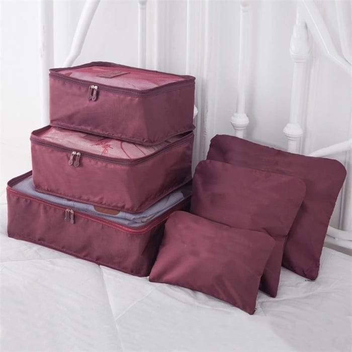 Reisender packt Koffer mit dem praktischen 6-teiligen Reise Packwürfel Set für mehr Ordnung im Gepäck. Unisex.
