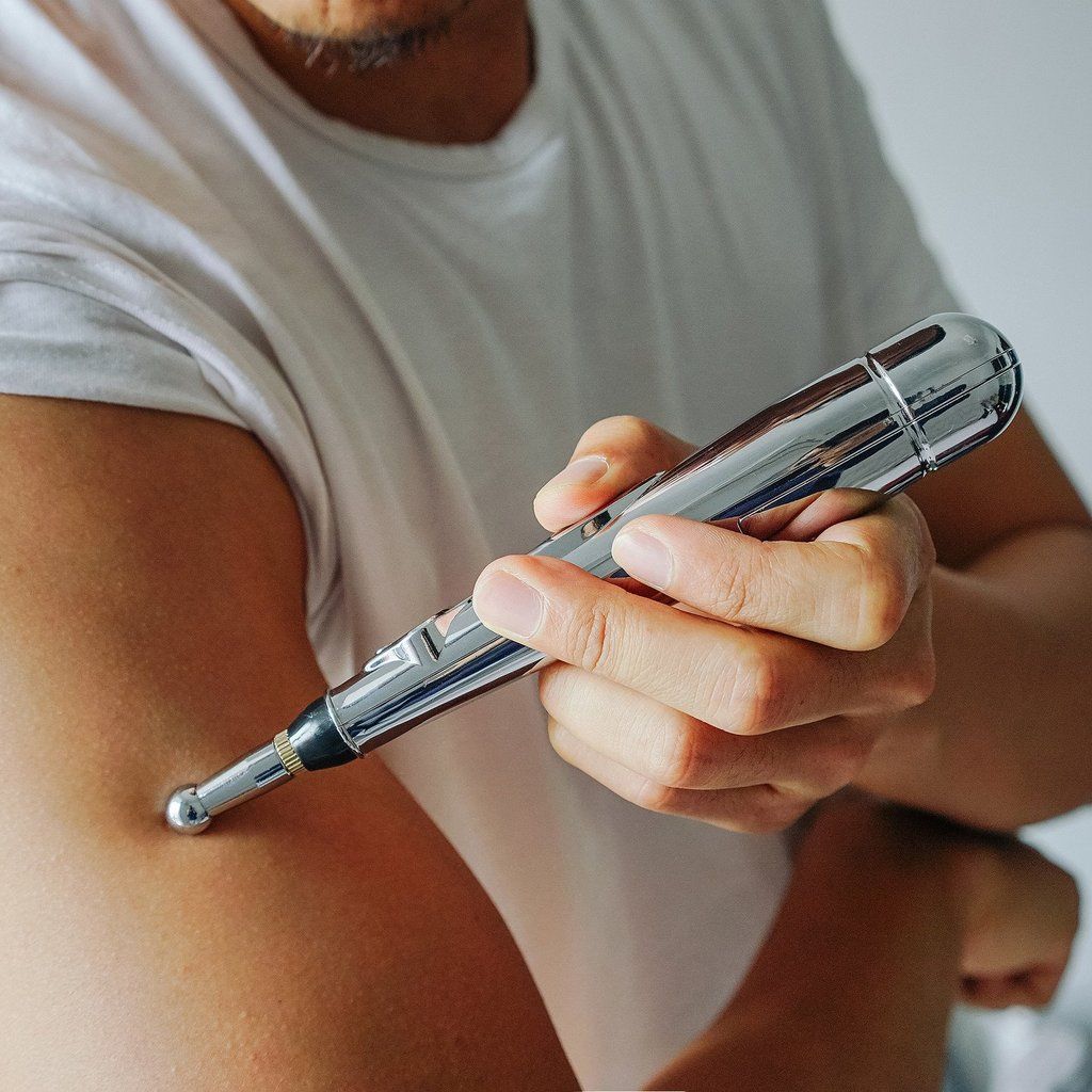 Moderner Akupunktur-Stift mit verschiedenen Aufsätzen für effektive Schmerzlinderung und tiefe Muskelentspannung.