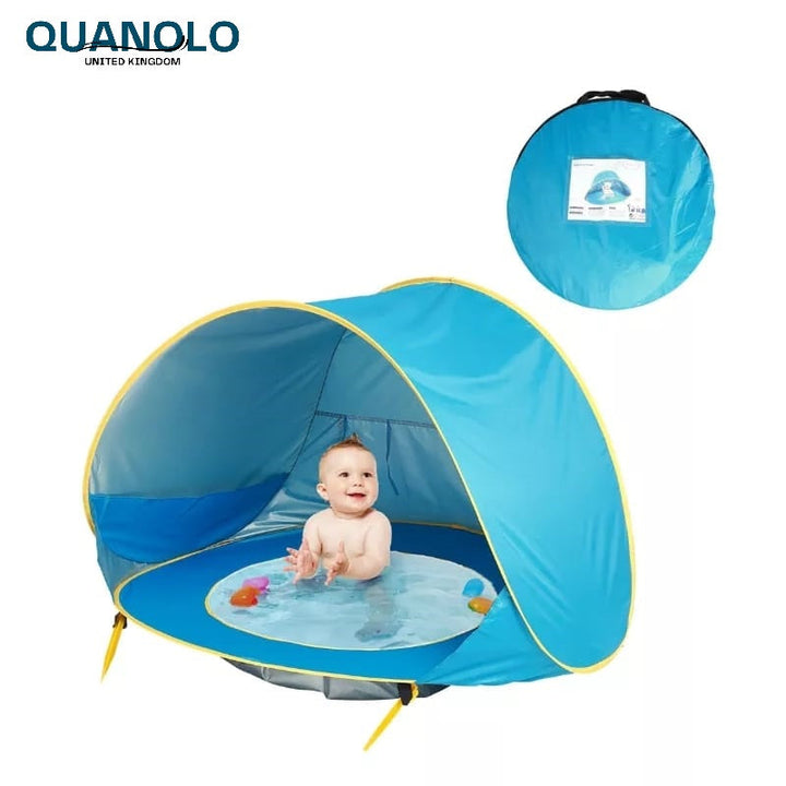 Blaues Baby Pop-Up Strandzelt mit UV-Schutz, am Meer aufgebaut. Bietet Schatten & sicheren Spielbereich.