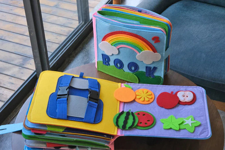 Offenes Montessori Filzbuch mit interaktiven Seiten: Knöpfe, Reißverschluss, Formen und Spiele für Kinder.