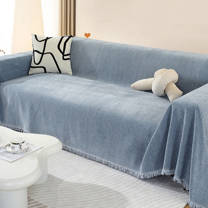 Chenille Couchbezug in Fischgrätenmuster mit Quasten, schützt Sofa stilvoll im Wohnzimmer.