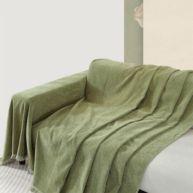 Moderner Couchschutz: Chenille Überwurf im Fischgrätenmuster mit schönen Quasten.