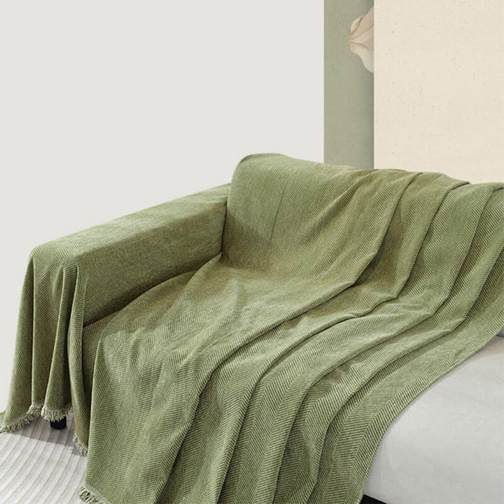 Moderner Couchschutz: Chenille Überwurf im Fischgrätenmuster mit schönen Quasten.