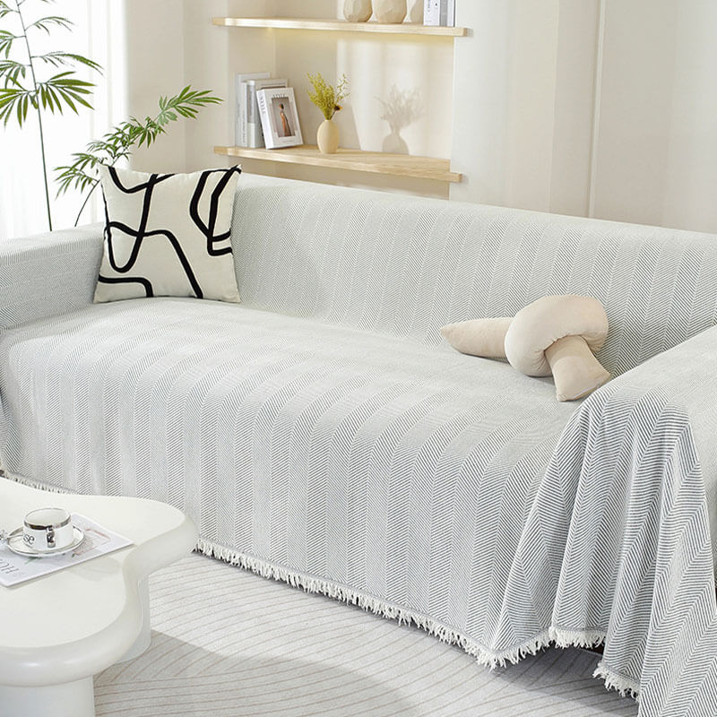 Eleganter Couch-Überwurf aus Chenille mit Fischgrätenmuster und dekorativen Quasten.