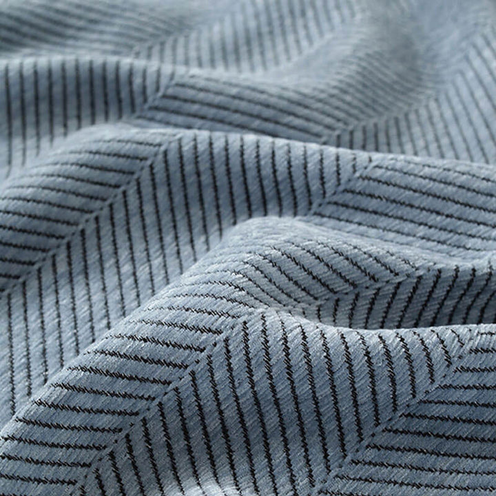 Detailaufnahme: Weiche Chenille-Struktur des Couchbezugs mit markantem Fischgrätenmuster.