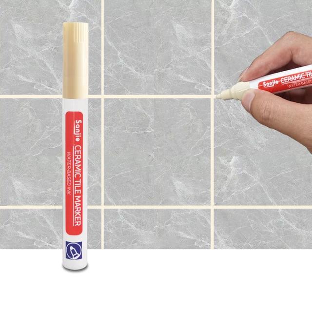 Fugenstift im Einsatz in einem Badezimmer, erneuert die Optik alter Fliesen.