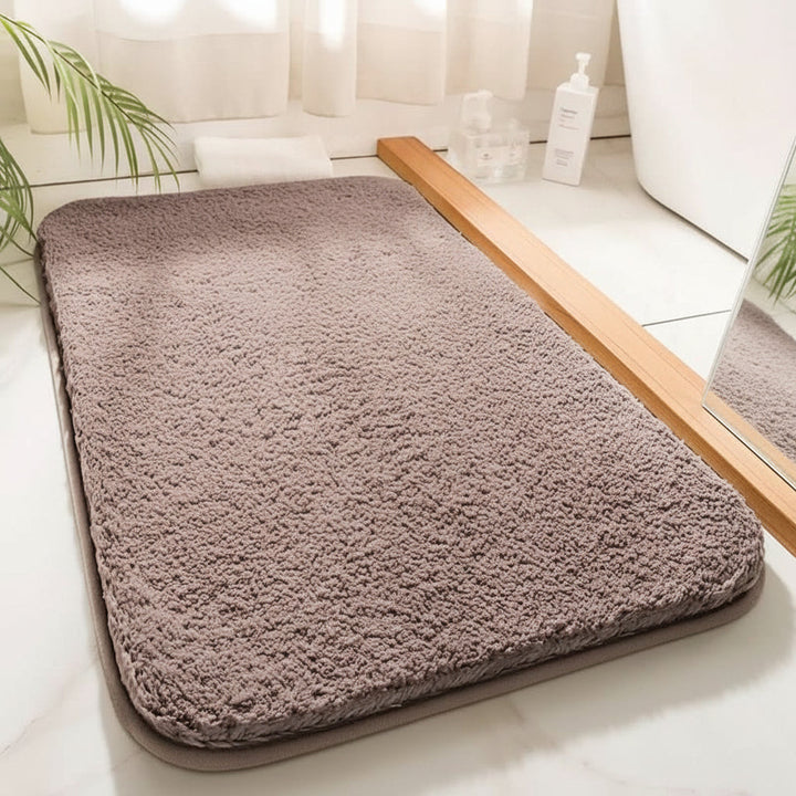 Hochsaugfähige CLOUDLUXE Badematte für trockene Füße & Komfort nach dem Duschen im luxuriösen Badezimmer.