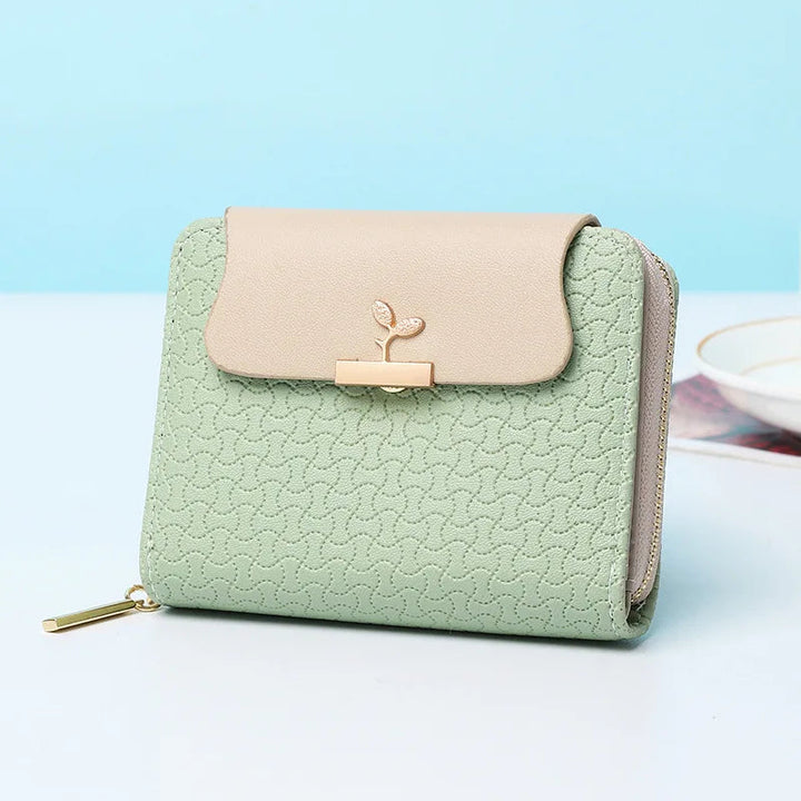 Nahaufnahme der eleganten Blätter-Prägung auf modischer Damen Geldbörse. Stilvolle Clutch.
