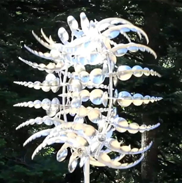 Detailaufnahme der Metall-Windmühle, kunstvolle Gartendekoration, präzise gefertigtes Windspiel.