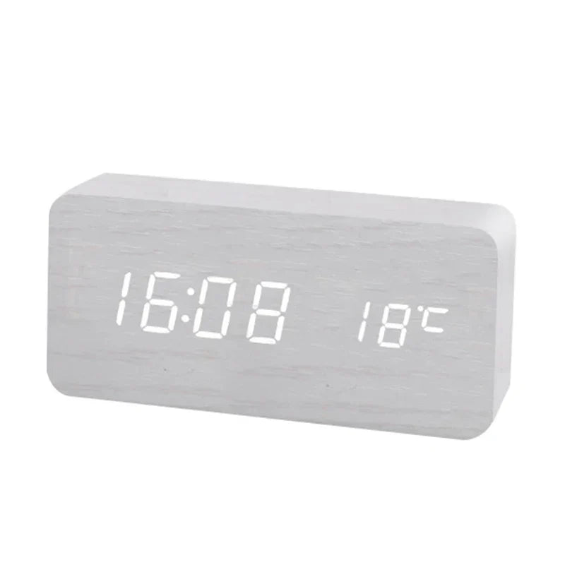 Detailansicht eines digitalen Holz-Weckers mit leuchtender LED-Anzeige für Uhrzeit und Temperatur.