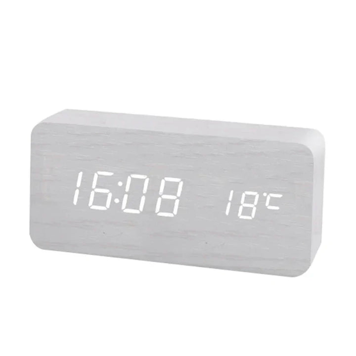 Detailansicht eines digitalen Holz-Weckers mit leuchtender LED-Anzeige für Uhrzeit und Temperatur.