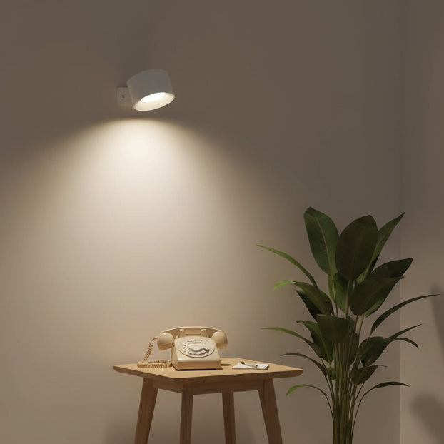 Minimalistische LumiSpin LED Wandleuchte, kabellos & wiederaufladbar, ideal als Leselampe im Schlafzimmer.