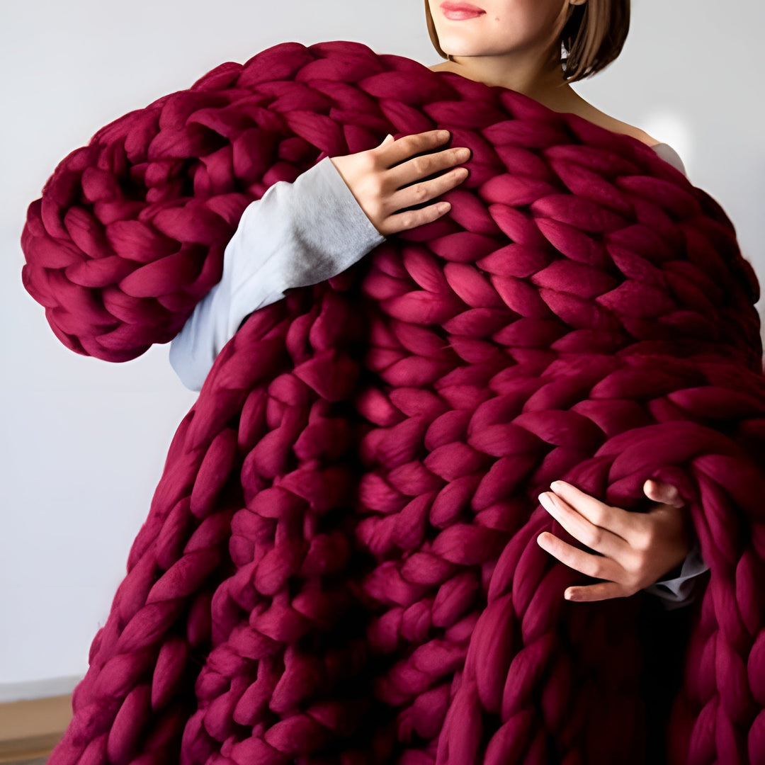 Abbildung einer gestrickten Kuscheldecke, gefertigt mit dem DIY Strickset, zeigt Gemütlichkeit und Wohnkultur.