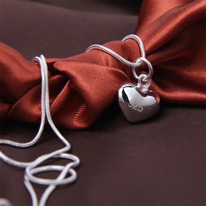 Nahaufnahme des glänzenden 925 Sterling Silber Herzanhängers an einer zarten Schlangenkette, ideal für Frauen.