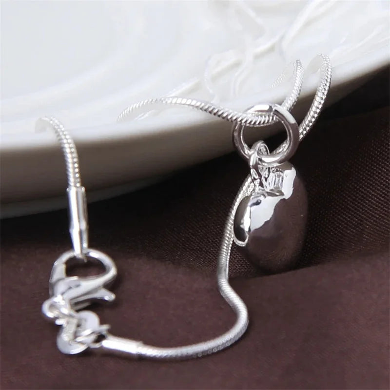 Frau trägt stilvolle Silberkette mit Herzanhänger aus 925 Sterling Silber. Ein elegantes Schmuckstück für Frauen.