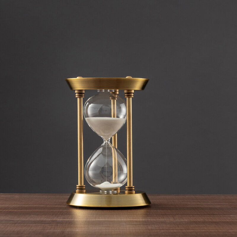 Bronze-Sanduhr im Retro-Design auf einem Holzschreibtisch. Ein elegantes Desktop-Ornament und praktischer Zeitmesser.