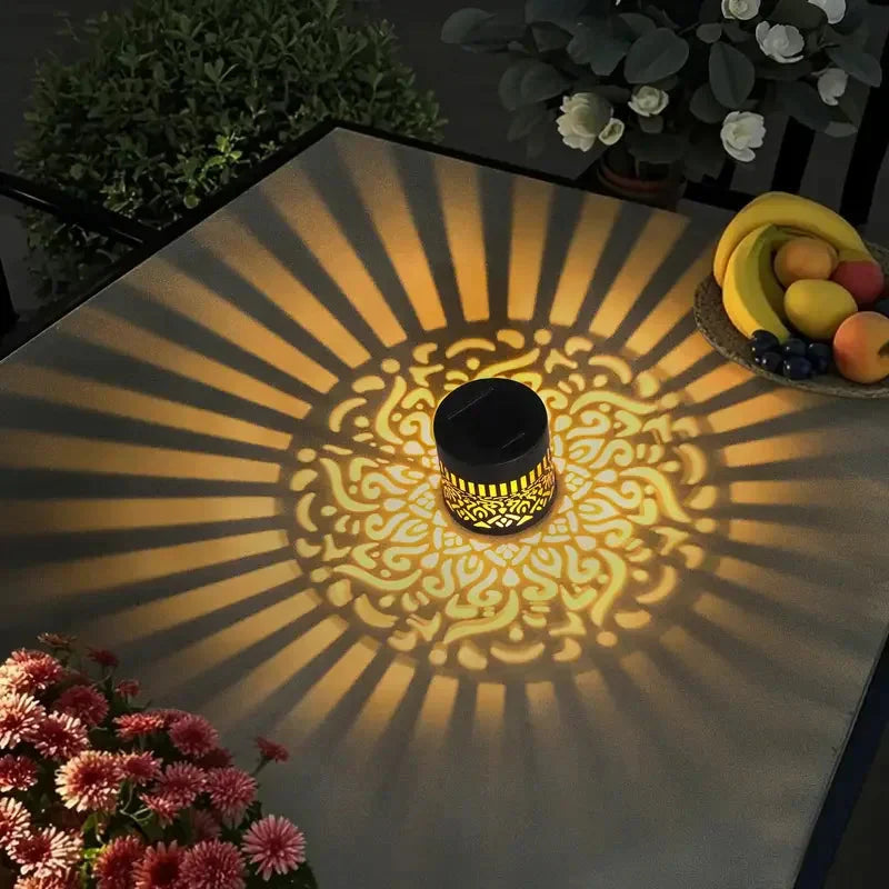 Dämmerungssensor-Solarleuchte für den Garten, die automatisch ein atmosphärisches Schattenmuster projiziert.