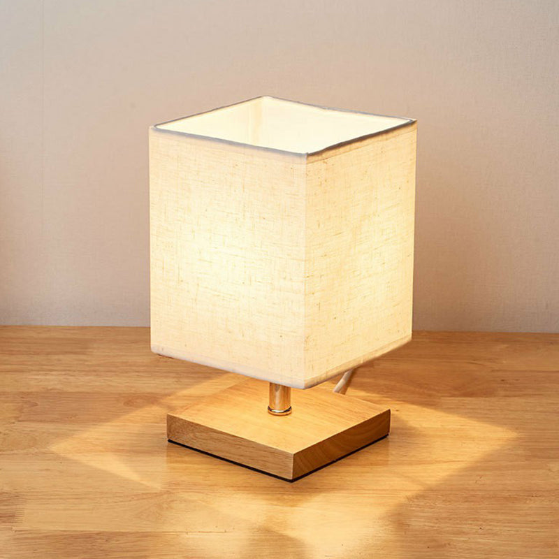 Minimalistische, skandinavische Tischlampe mit Holzfuss und Leinenschirm für modernes Wohnambiente. Deko-Beleuchtung.
