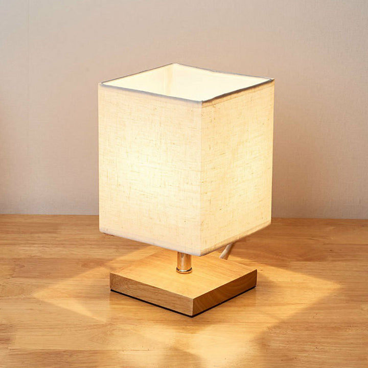 Minimalistische, skandinavische Tischlampe mit Holzfuss und Leinenschirm für modernes Wohnambiente. Deko-Beleuchtung.
