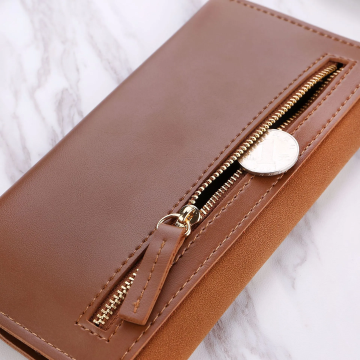 Unisex Geldbörse lang, elegant in der Hand gehalten, mit auffälligem Goldverschluss als Highlight.