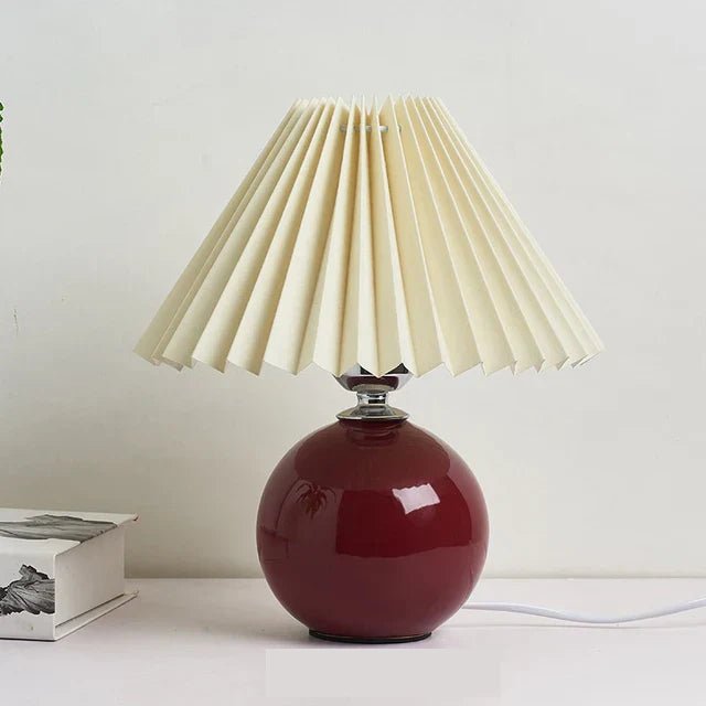 Elegante Vintage-Tischlampe mit faltbarem Stoffschirm und warmem Glanz, ideal für Schlaf- oder Wohnzimmer.