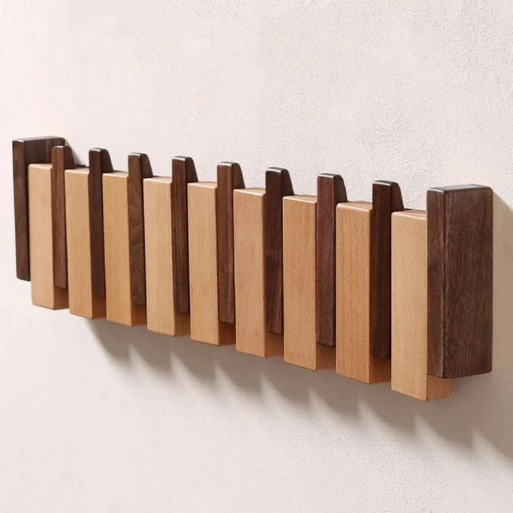 Stilvolle Wandgarderobe aus Nussbaumholz, handgefertigt, im Klavierdesign mit praktischen Klapphaken.