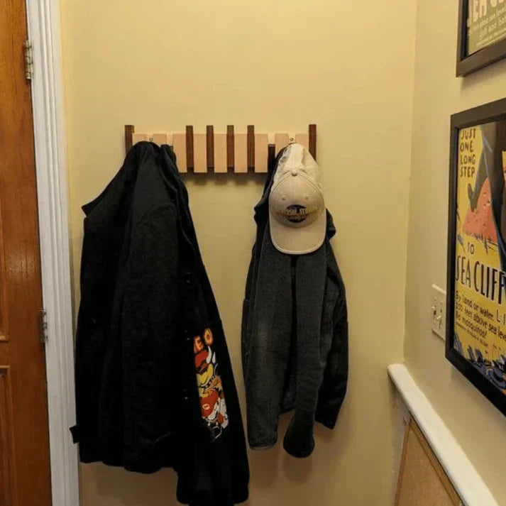Detailaufnahme der schwarzen Haken eines Klavier-Kleiderhakens aus Holz, ideal für Mäntel.