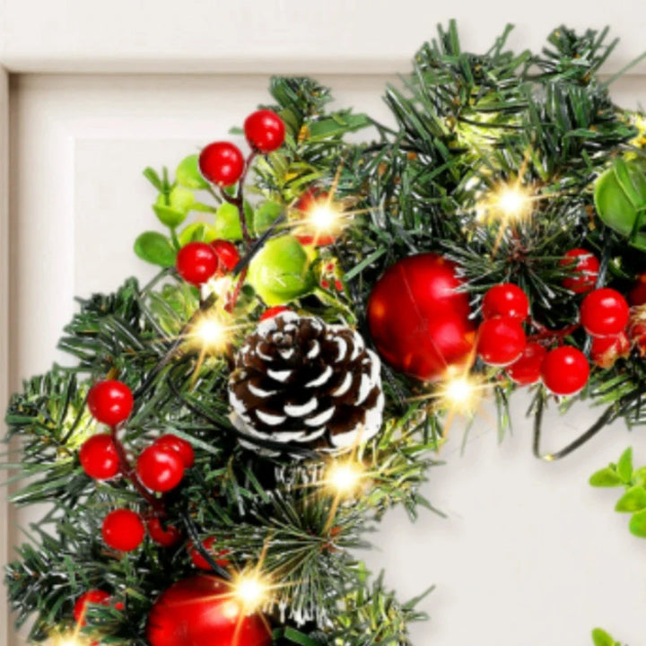 Stilvoller Weihnachtskranz mit LED-Licht, leuchtend roten Beeren & einer dekorativen Schleife für Winterdekoration.