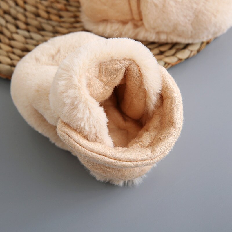 Ein Baby trägt flauschige, warme Hausschuhe. Kuschelige Kleinkinderschuhe für gemütliche Füße im Winter.