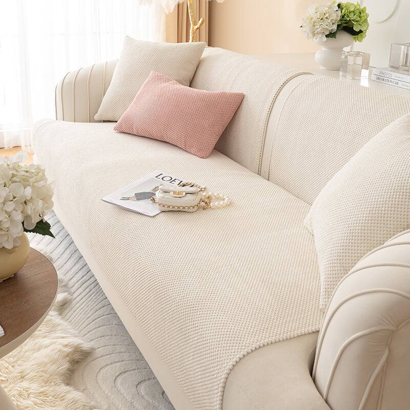 Rutschfester Plüsch Sofabezug in Grau. Schützt Ihre Couch stilvoll und sorgt für Gemütlichkeit im Wohnzimmer.