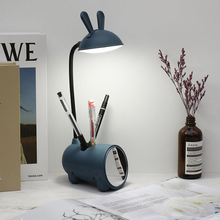 Blaue BunnyGlow LED-Schreibtischlampe mit Stifthalter und flexiblem Hals für optimales Licht.