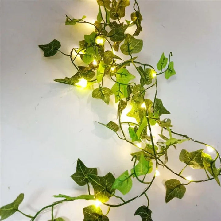 Nahaufnahme: Grüne LED-Lichterkette mit detaillierten Blättern, batteriebetrieben, für stimmungsvolle Beleuchtung.