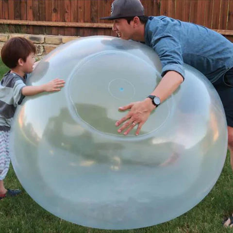 Kinder lachen und spielen aktiv mit dem riesigen Outdoor Bubble-Ball im Garten. Perfektes Sommer-Wasserspielzeug.