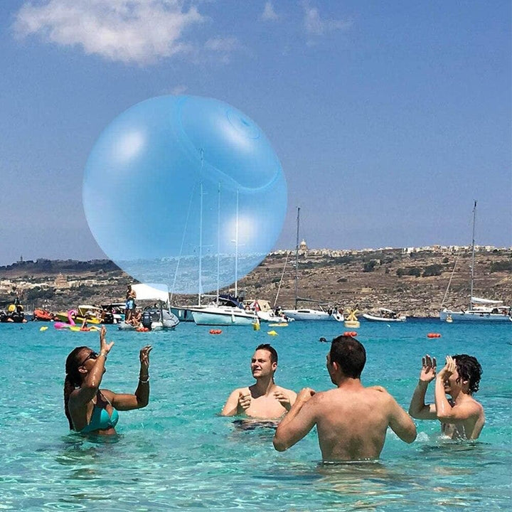 Blauer riesiger Bubble-Ball am Sandstrand für Wasserspiel und aktiven Familienspaß. Ideal für Strandspielzeug.