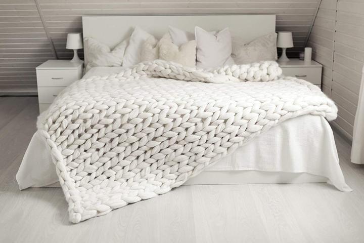 Dekorative Baumwolldecke in Grobstrick-Optik. Diese gemütliche Kuscheldecke wärmt Sie im Wohnzimmer.