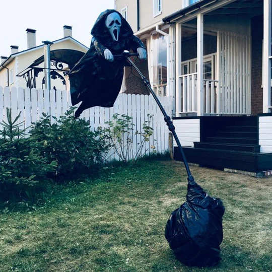 Schreckgespenst Halloween-Vogelscheuche mit Scream-Maske und zerrissenem Outfit als Spuk-Deko für Veranda.