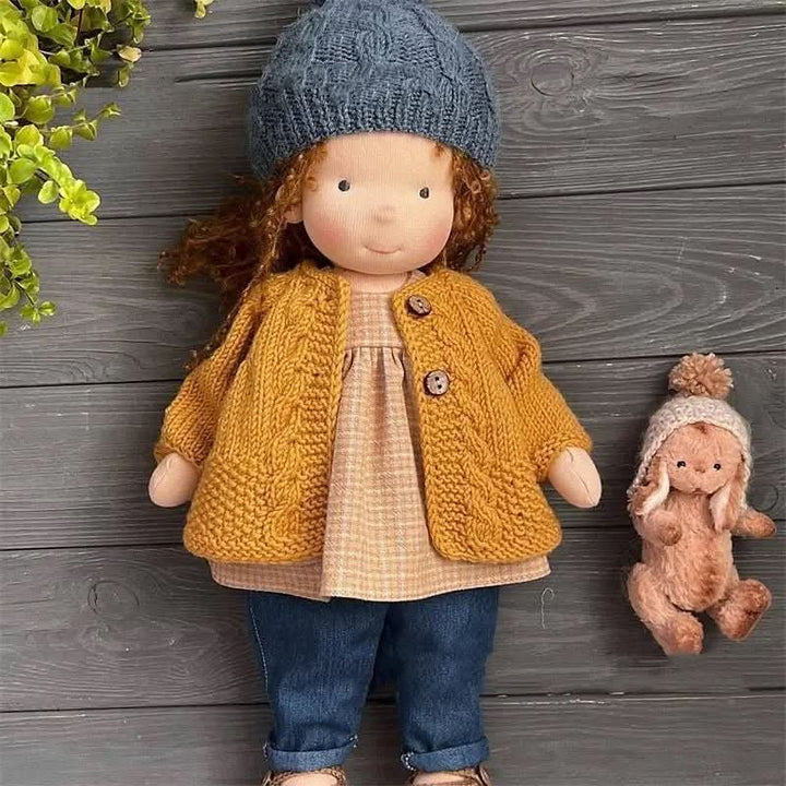 Waldorf-Puppe sitzt auf einem Stuhl, bereit für das Rollenspiel der Kinder, handgefertigt aus Baumwolle.