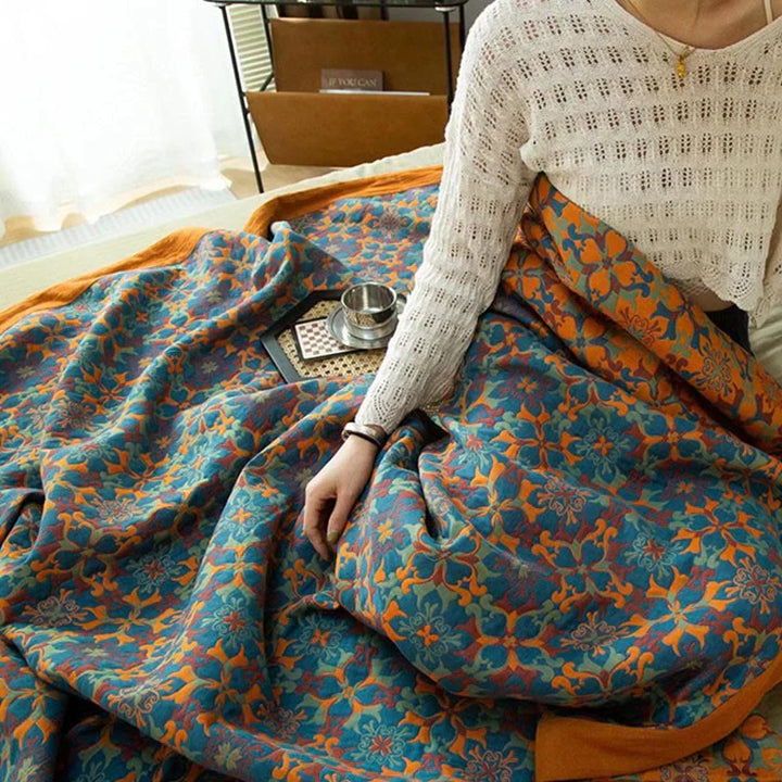Design-Baumwollsteppdecke, orange-blau gemustert. Perfekte Heimtextilie für Herbst & Winter.