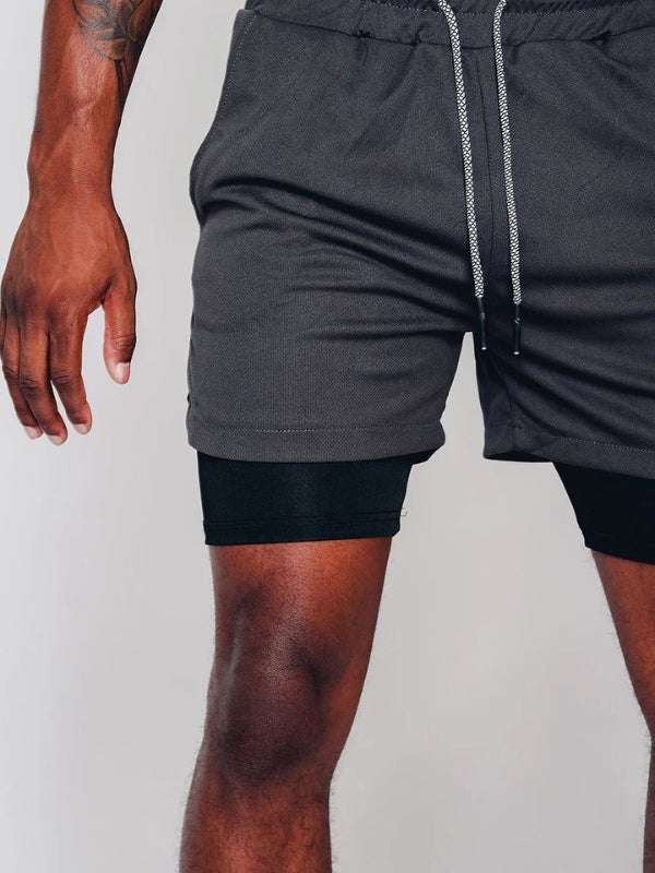 Seitliche Schlitze am Saum der Herren 2-in-1 Shorts für uneingeschränkte Bewegungsfreiheit beim Sport.