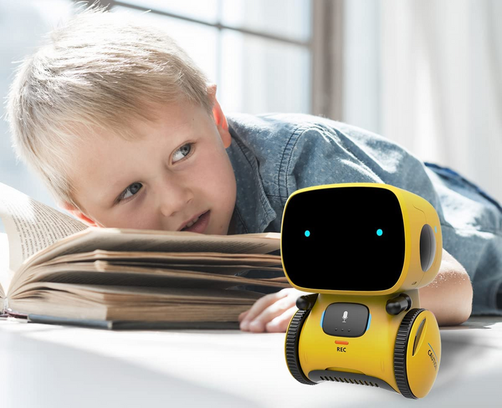 Kind spielt lachend mit dem singenden und tanzenden Spielzeug Roboter.