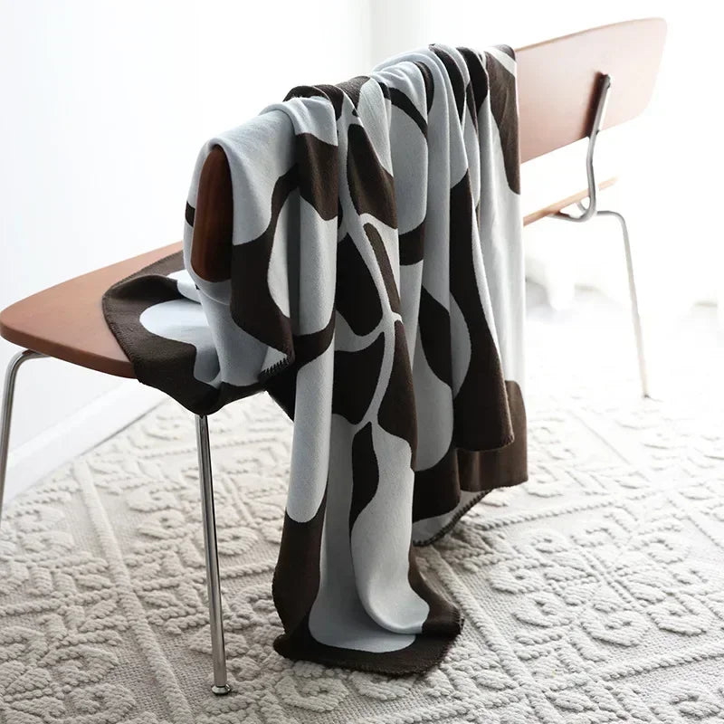 Grüne Jacquard Heimtextilie im skandinavischen Design, als wärmende Kuscheldecke für Sofa oder Bett.