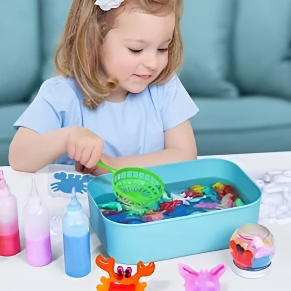 Kind gießt AquaKreativ Flüssigkeit in Form, um eine blaue Meeresschildkröte zu gestalten. Kreativer Spielspaß.
