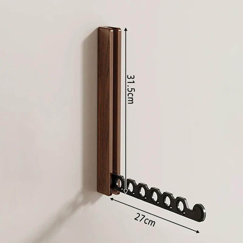 Wandgarderobe ausgeklappt: Zeigt den funktionalen Klappkleiderständer mit aufgehängten Kleidungsstücken.