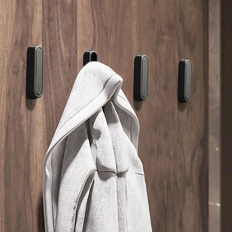 Eleganter klappbarer Metallhaken an einer weißen Wand, betont das minimalistische & moderne Design.