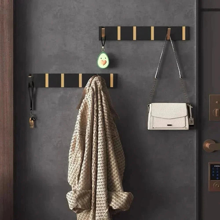 Moderner FOLDHOOK Wandhaken, eingeklappt an weißer Wand. Platzsparendes, minimalistisches Design.