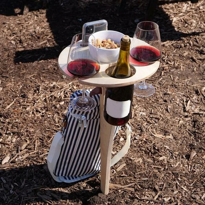 Klappbarer Weintisch aus hellem Holz für Outdoor-Picknicks. Ideal für Garten, Strand & Camping; sicherer Halt für Flasche & Gläser.