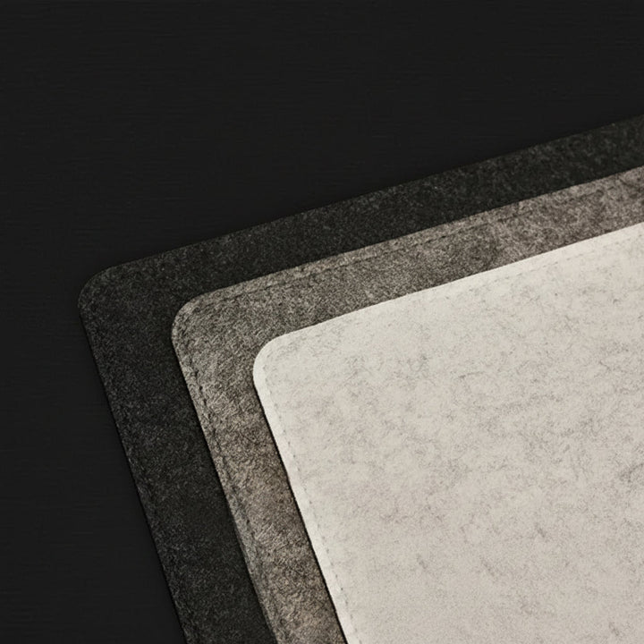 Nahaufnahme der weichen Wollfilz-Textur einer grauen Schreibtischunterlage. Komfortabel und rutschfest.