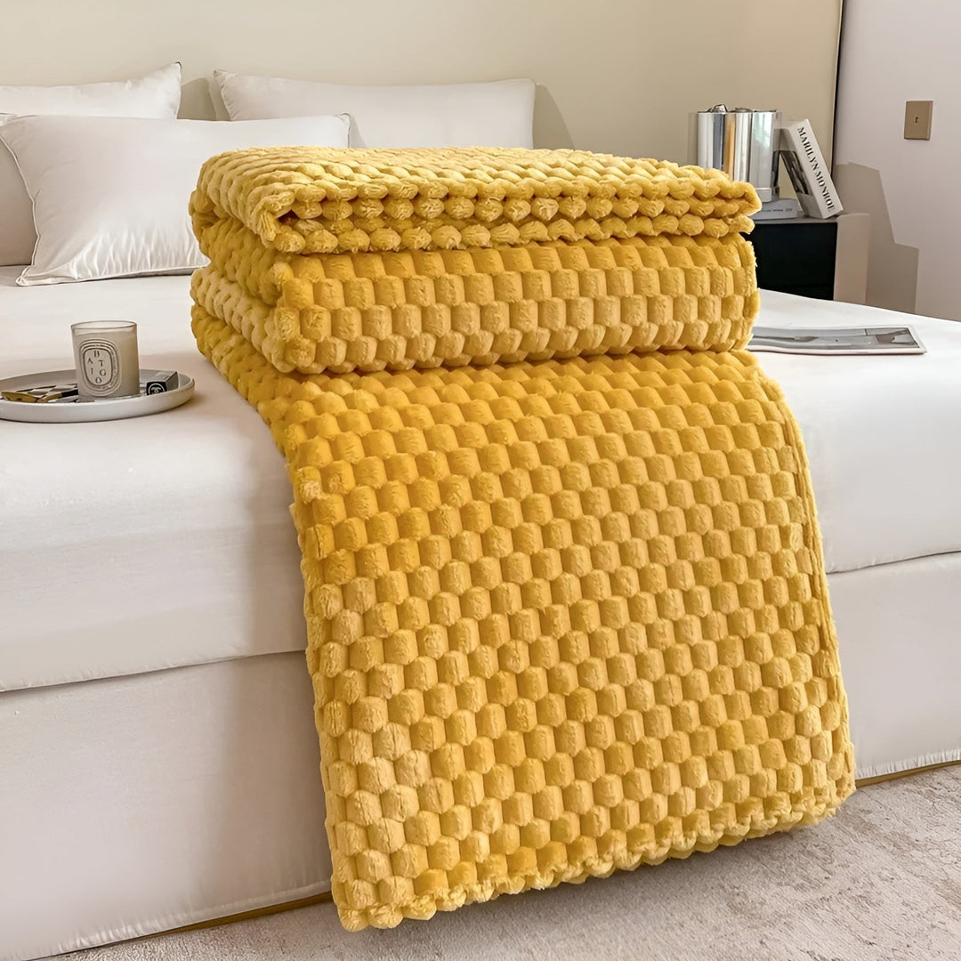 Person gemütlich eingekuschelt in eine warme, superweiche Mikrofaser Kuscheldecke auf dem Bett.
