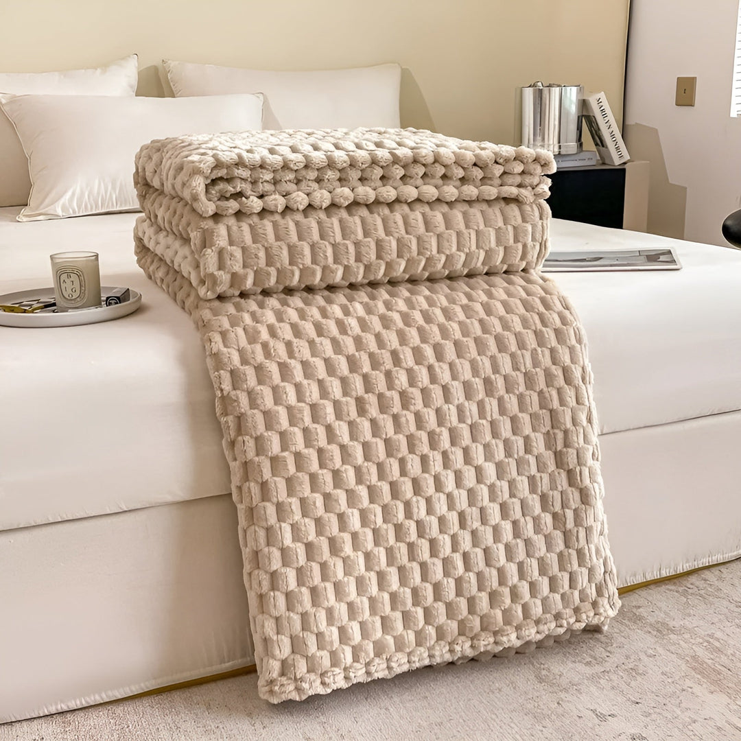 Ordentlich gefaltete, superweiche Kuscheldecke auf einem Sofa, warm und einladend für gemütliche Stunden.