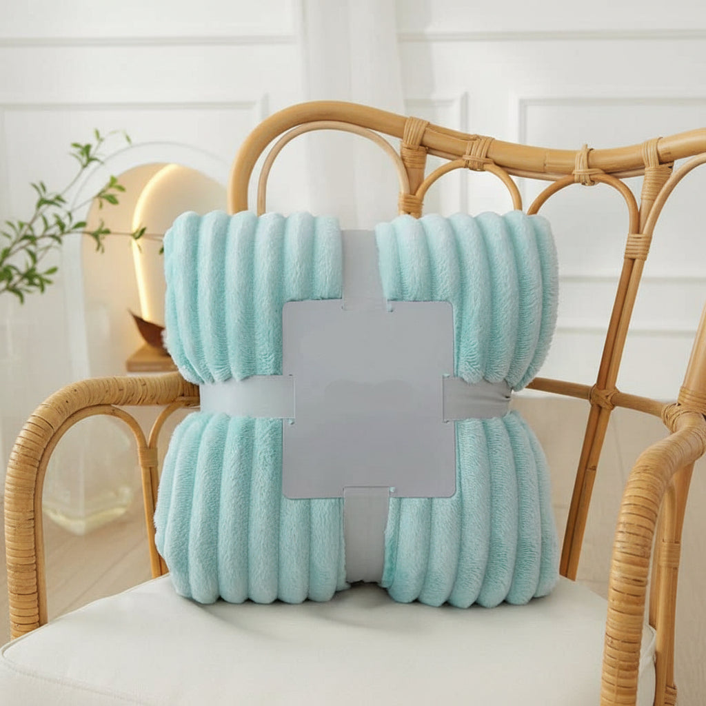 Ordentlich gefaltete Flanell-Fleece-Decke mit eleganten Streifen, bereit für gemütliche Stunden auf dem Sofa.